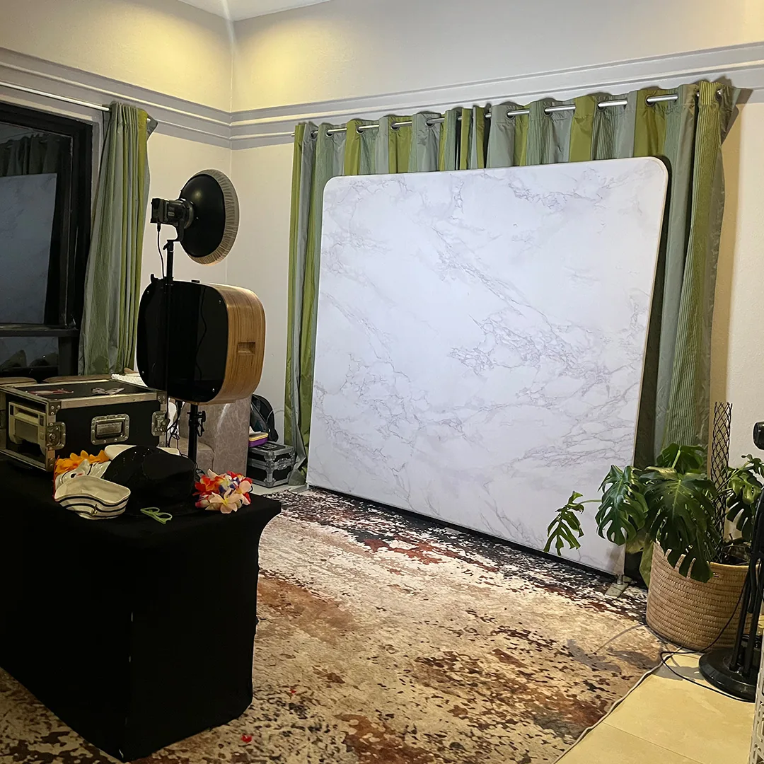 Open photo booth with a backdrop, camera and printer at an evening event